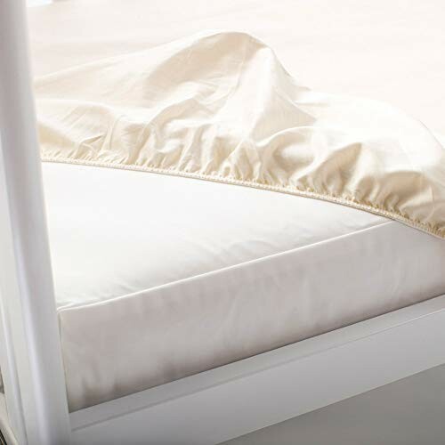 Fitted bed sheet partially covering a mattress.