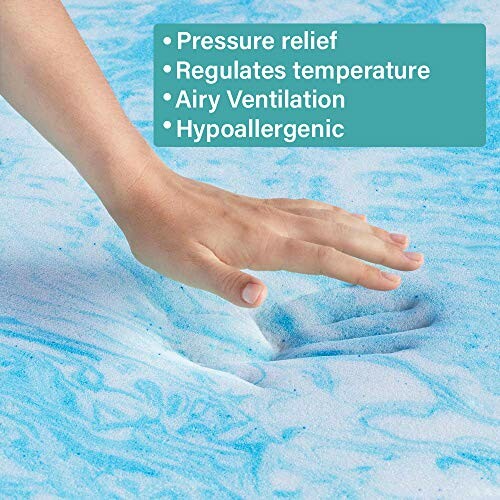 Hand pressing into blue memory foam mattress.