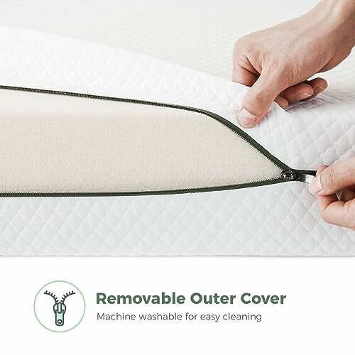 Hands opening removable mattress cover with zipper.
