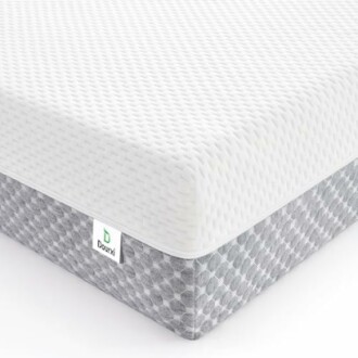 Corner of a memory foam mattress with a white textured top and gray patterned sides.