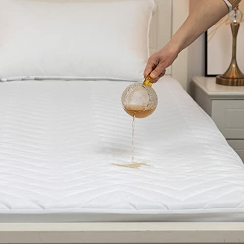 Person pouring liquid on a waterproof mattress protector